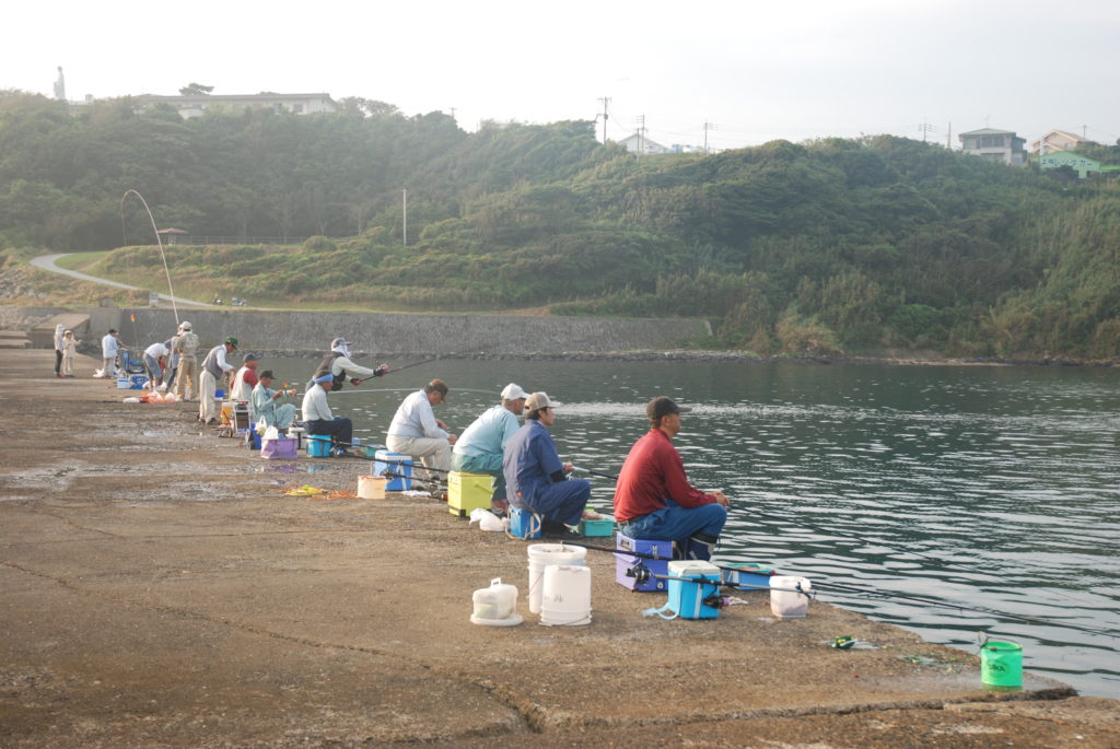 漁港で釣りをする人々